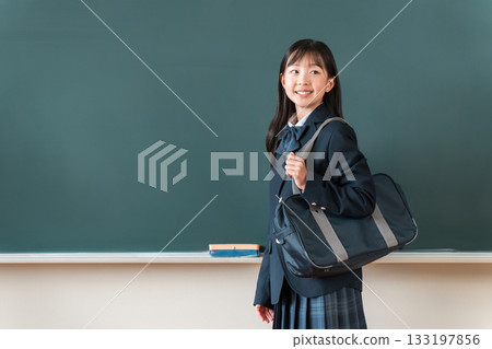 Female students in uniforms holding school bags standing in front of the blackboard in the classroom, elementary school, junior high school, and high school students Female students in uniforms holding school bags standing in front of the blackboard in the classroom, elementary school, junior high school, and high school students 133197856