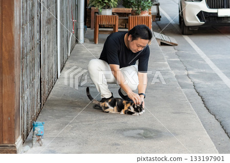 Small Encounters, he stops for a moment to pet a stray cat reminding that small connections can bring unexpected joy and meaning. Small Encounters, he stops for a moment to pet a stray cat reminding that small connections can bring unexpected joy and meaning. 133197901