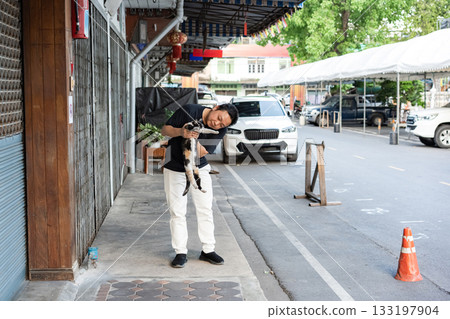 Gentle Encounter, a man carefully lifts a cat in his arms sharing a quiet moment of trust tenderness and connection between human and animal. Gentle Encounter, a man carefully lifts a cat in his arms sharing a quiet moment of trust tenderness and connection between human and animal. 133197904