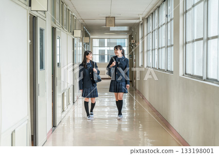 穿著制服的小學生、國中生、高中生和女高中生走在學校走廊裡 133198001