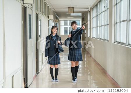 Elementary school students, junior high school students, high school students, and high school girls in uniform walking down the school corridor 133198004
