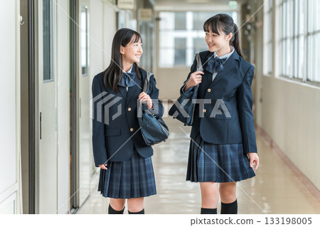 穿著制服的小學生、國中生、高中生和女高中生走在學校走廊裡 133198005