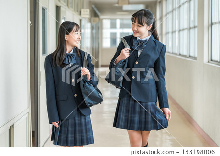 穿著制服的小學生、國中生、高中生和女高中生走在學校走廊裡 133198006