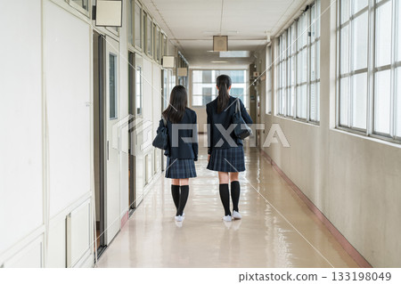 Back view of friends walking down a school corridor (elementary school students, junior high school students, high school students, and female high school students in uniform) 133198049