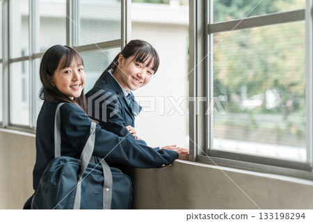 一群穿著校服的國中女生在學校走廊上聊天。 133198294