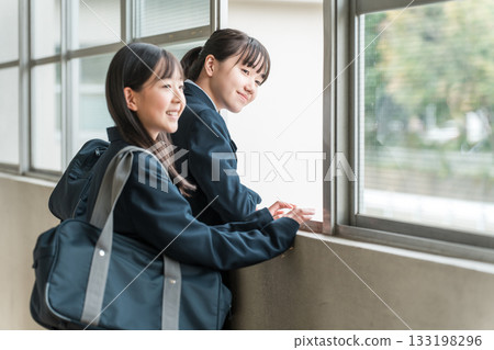 一群穿著校服的國中女生在學校走廊上聊天。 133198296