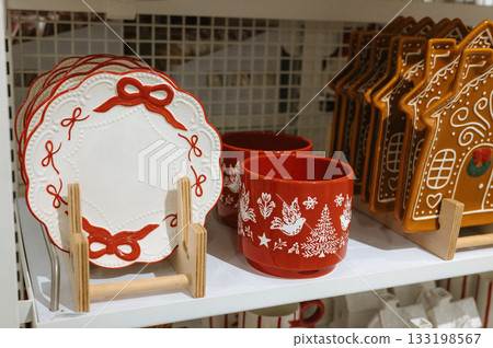 Festive ceramic holiday plates and mugs with red and white christmas designs Festive ceramic holiday plates and mugs with red and white christmas designs 133198567