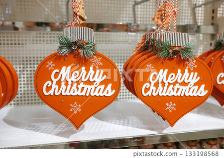 Festive merry christmas ornaments in retail display with snowflake decorations Festive merry christmas ornaments in retail display with snowflake decorations 133198568