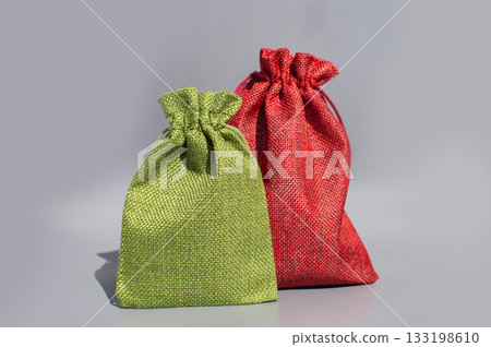 Two colorful fabric gift bags on gray background Two colorful fabric gift bags on gray background 133198610
