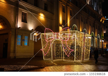 Illuminated gift box display with twinkling lights in urban nighttime setting 133198616