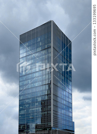 Modern glass building. Blue reflective windows on tall skyscraper with contemporary urban 133199695