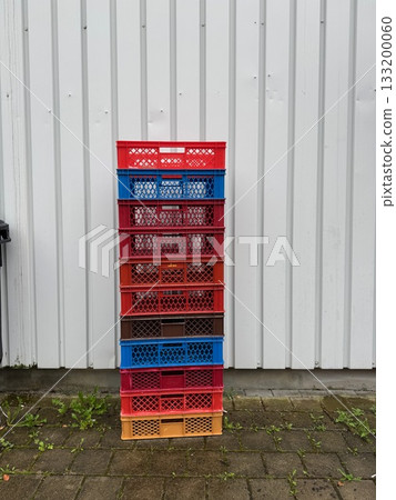 Stack of colorful plastic containers are arranged in a row Stack of colorful plastic containers are arranged in a row 133200060