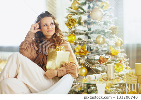 Thoughtful Woman with Gold Gift, Christmas Reflection Thoughtful Woman with Gold Gift, Christmas Reflection 133200740