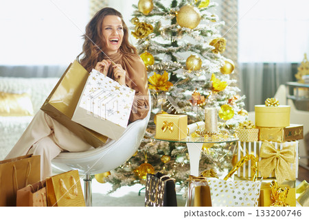 Woman Joyfully Surrounded by Golden Gifts 133200746