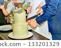 Elegant groom in blue suit cutting wedding cake 133201329