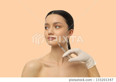 Professional administering cosmetic treatment to client 133201347