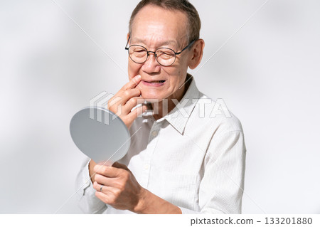 一位老人對著手鏡欣賞美景 133201880