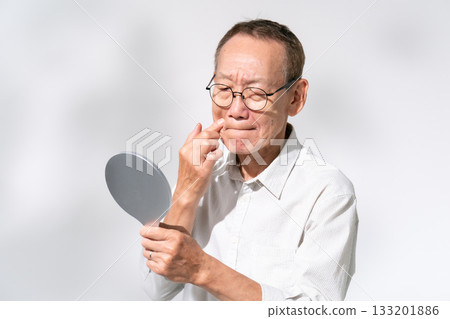 一位老人對著手鏡欣賞美景 133201886