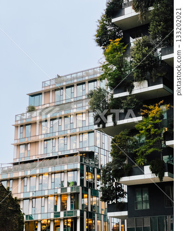 Vertical forest residential towers rising in Milan, featuring lush greenery cascading across concrete surfaces, embodying sustainable urban architectural design principles. Innovative architecture Vertical forest residential towers rising in Milan, featuring lush greenery cascading across concrete surfaces, embodying sustainable urban architectural design principles. Innovative architecture 133202021