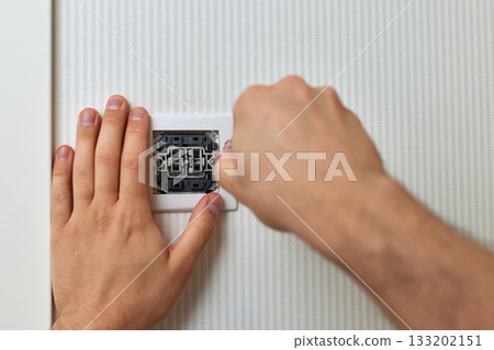 electrician installing electric light switch using screwdriver at home, close-up 133202151