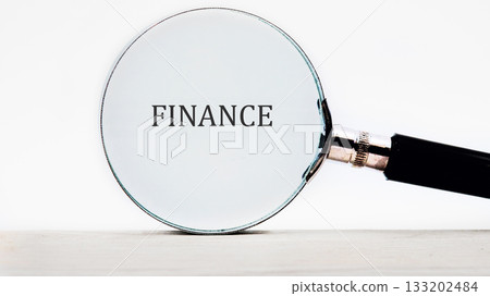 A magnifying glass is held over the word Finance. This highlights the importance of financial analysis and investigation for success and finding the details for market research A magnifying glass is held over the word Finance. This highlights the importance of financial analysis and investigation for success and finding the details for market research 133202484