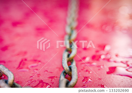 Diagonal metal chain on wet pink background Diagonal metal chain on wet pink background 133202690