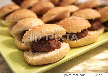 Tray of mini beef burgers in sesame buns Tray of mini beef burgers in sesame buns 133202700