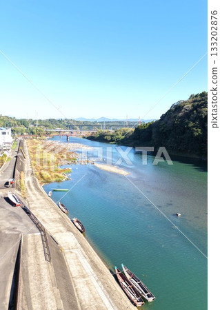 Scenery of the Kuma River behind the Hitoyoshi Senba in Kumamoto City, including sightseeing boats 133202876