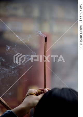 Woman burning incense and praying in Yonghe Temple of Tibetan Buddhism in Dongcheng District in Beijing, China 133203569
