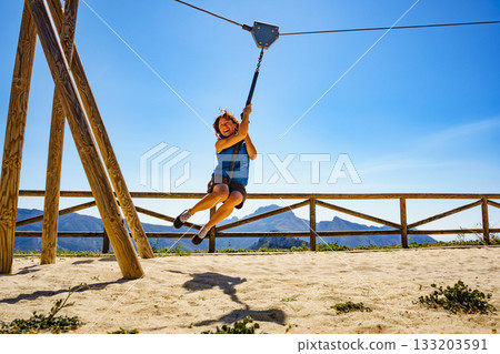 Adult woman having fun on zipline Adult woman having fun on zipline 133203591