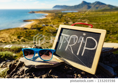 Black board with word trip against sea coast Black board with word trip against sea coast 133203598