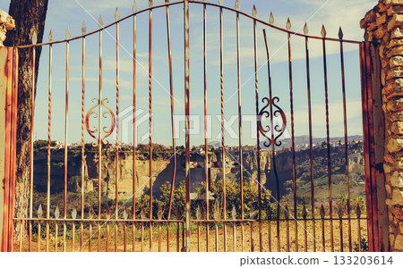 Old gate and Ronda town in distance, Spain. Old gate and Ronda town in distance, Spain. 133203614
