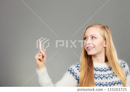 Teenage blonde woman pointing at copyspace Teenage blonde woman pointing at copyspace 133203725