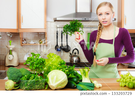 Woman housewife in kitchen with green vegetables Woman housewife in kitchen with green vegetables 133203729