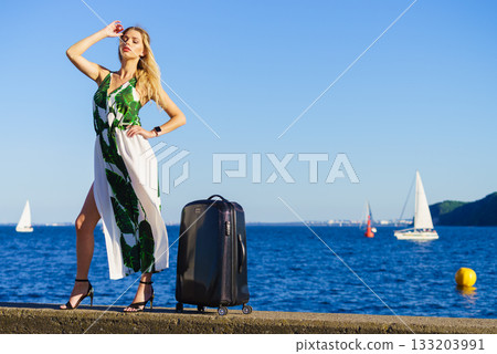 woman with suitcase against yachts on sea woman with suitcase against yachts on sea 133203991