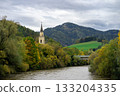 Panoramic view of the church spire among the autumn city against the background of the Austrian Alps and the river 133204335