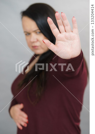 Woman showing stop hand sign gesture. Woman showing stop hand sign gesture. 133204414