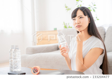 A young woman checking disaster prevention supplies 133204477