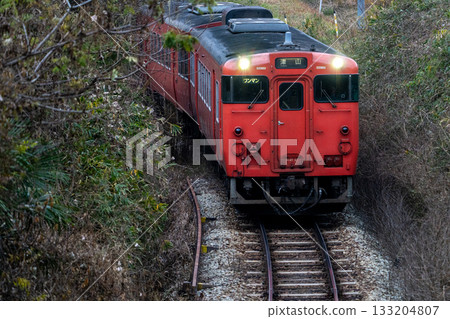 開往津山線津山站的當地列車正沿著冬季的斜坡向下行駛。岡山縣岡山市北區。 133204807