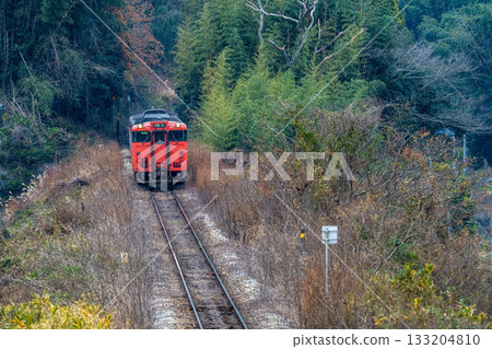 Kotobuki 2, a rapid train bound for Okayama Station on the Tsuyama Line, climbs a winter hill in Kita Ward, Okayama City, Okayama Prefecture 133204810