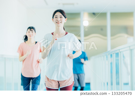 Men and women running on an indoor track 133205470