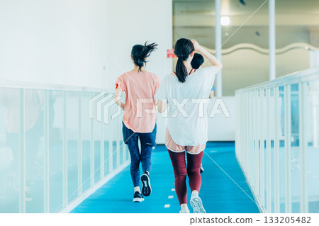 Men and women running on an indoor track 133205482