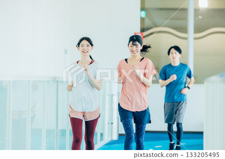Men and women running on an indoor track Men and women running on an indoor track 133205495