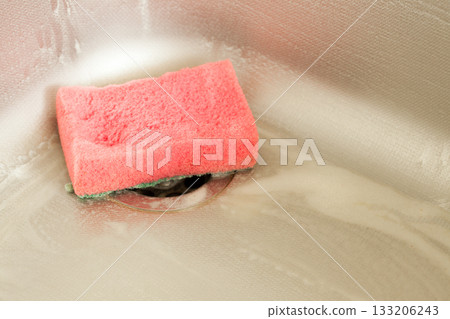 Washing dishes. Kitchen sink with foam sponge. 133206243