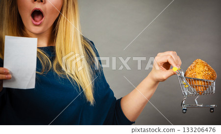 Shocked woman holding shopping basket with bread Shocked woman holding shopping basket with bread 133206476