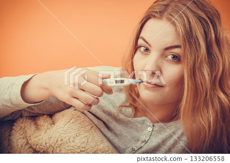 Sick ill woman with digital thermometer in mouth. Sick ill woman with digital thermometer in mouth. 133206558