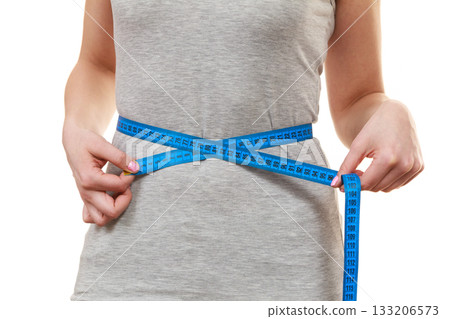 Woman measuring her waist closeup Woman measuring her waist closeup 133206573