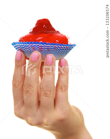 Delicious tasty sweet cake cupcake in human hand. Delicious tasty sweet cake cupcake in human hand. 133206574