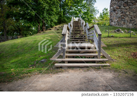 Wooden staircase leading uphill in a green park surrounded by trees Wooden staircase leading uphill in a green park surrounded by trees 133207156