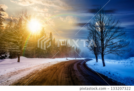 winding road through winter forest. day and night time change concept. beautiful nature scenery with naked trees on foggy weather with sun and moon at twilight. duality and transition template winding road through winter forest. day and night time change concept. beautiful nature scenery with naked trees on foggy weather with sun and moon at twilight. duality and transition template 133207322